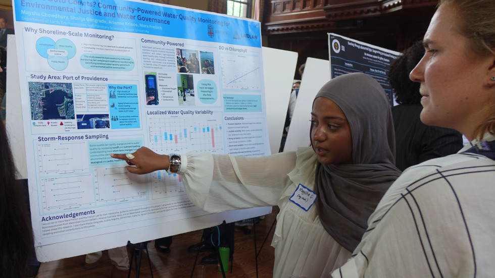 Maysha Chowdhury discussing her poster with a peer 