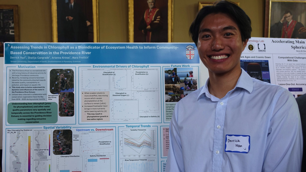 Derrick Han smiling beside his poster 