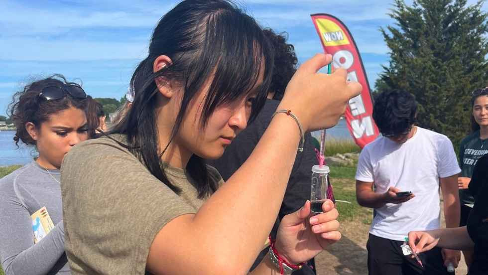 a student using a syringe to measure a water sample
