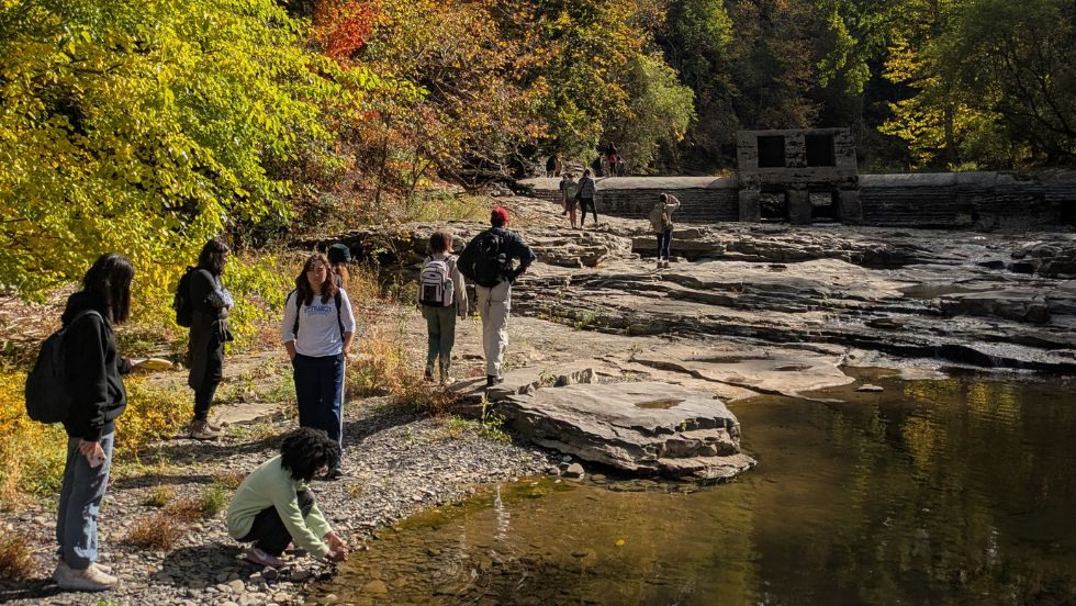 students walking along a rocky creek bed