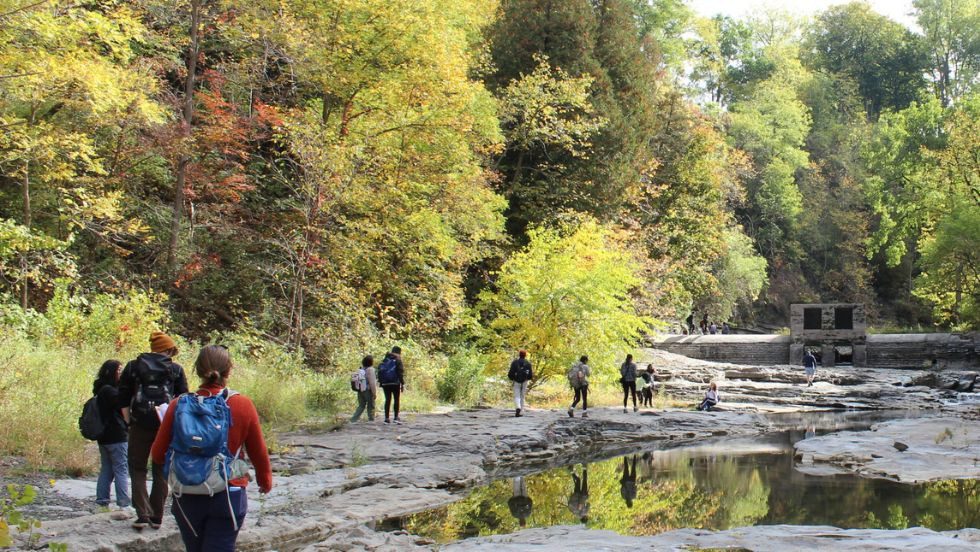 students hiking along a rocky creek bed